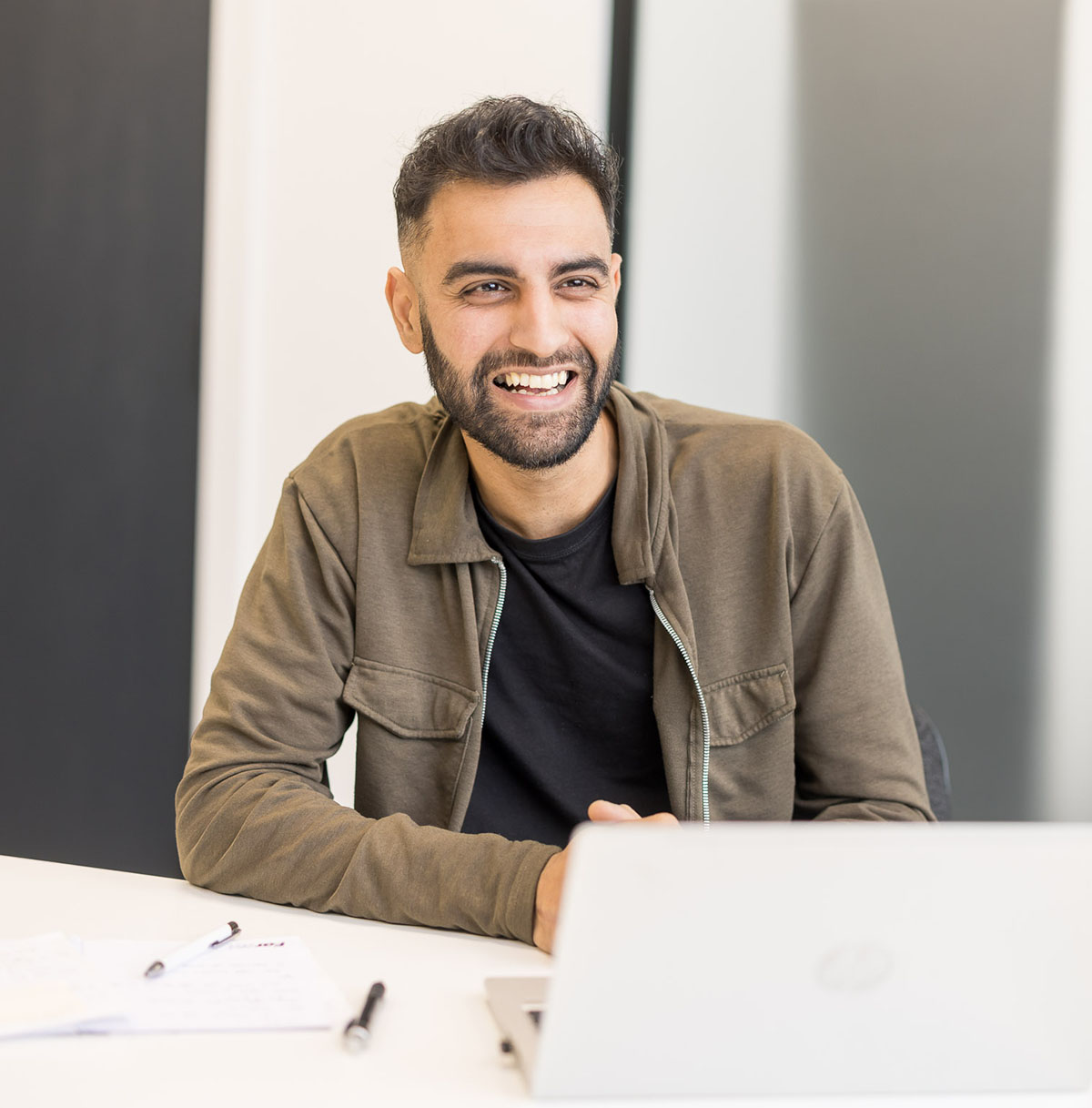 A happy, smiling man in an office environment